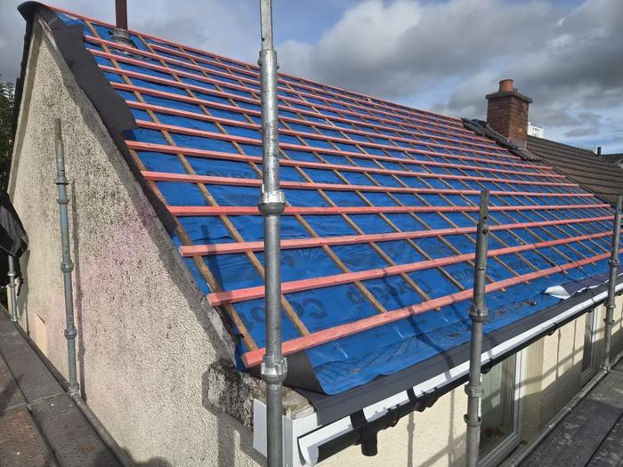 Blue breathable membrane and new red battens on a gable roof
